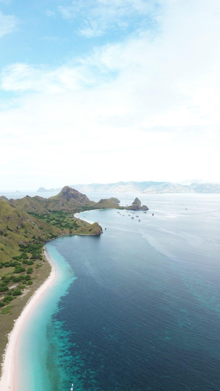 Padar – Aerial coastline, green headland, white beach (Real photo from a Komodo Explorer trip)